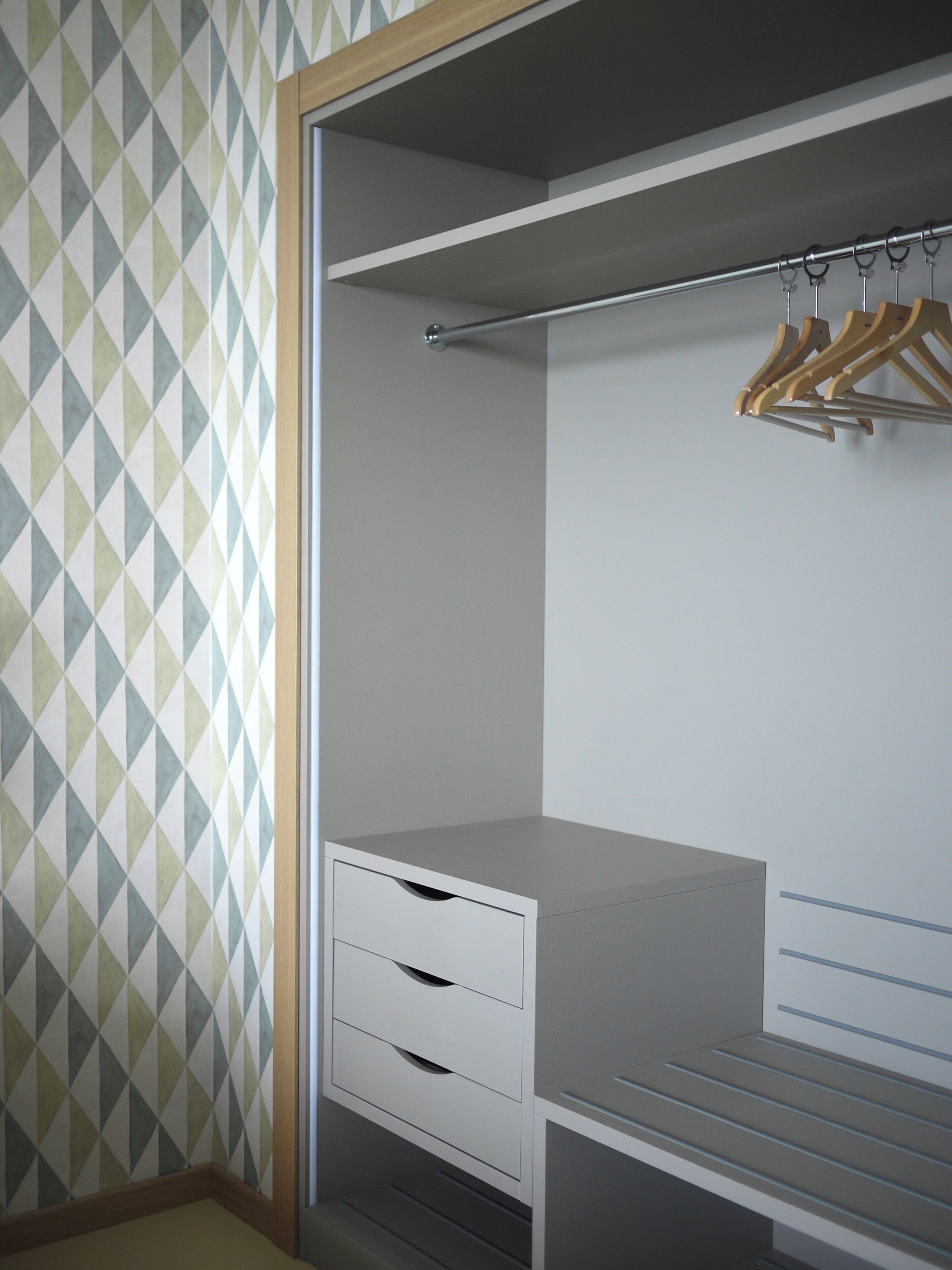 A walk-in closet with a mirrored closet rod and a hanging rack.