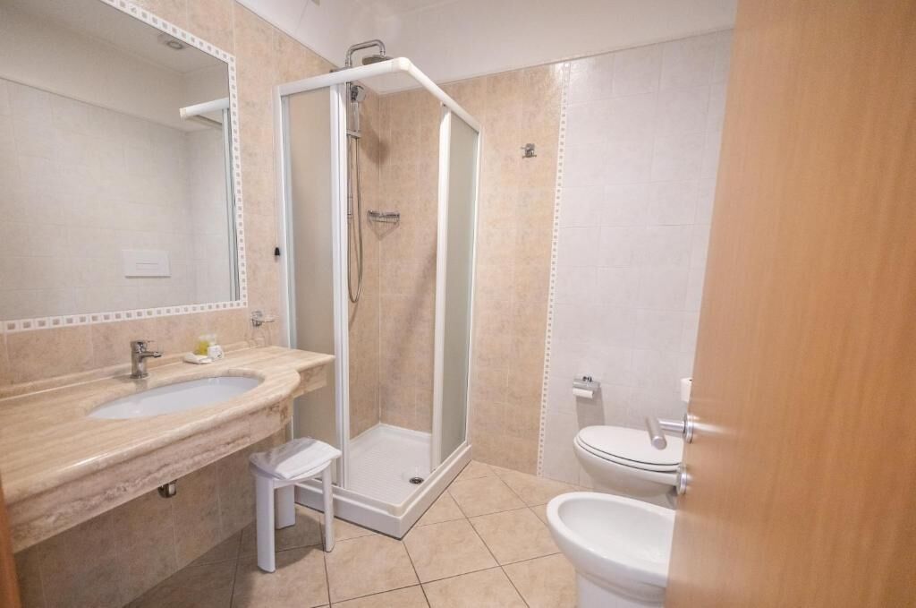 Un baño con ducha, lavamanos e inodoro.