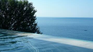 A clear view of a beach with a pool and a boat in the distance.