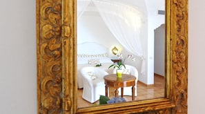 A bedroom with a bed, a bedside table with a plant, and a chair.