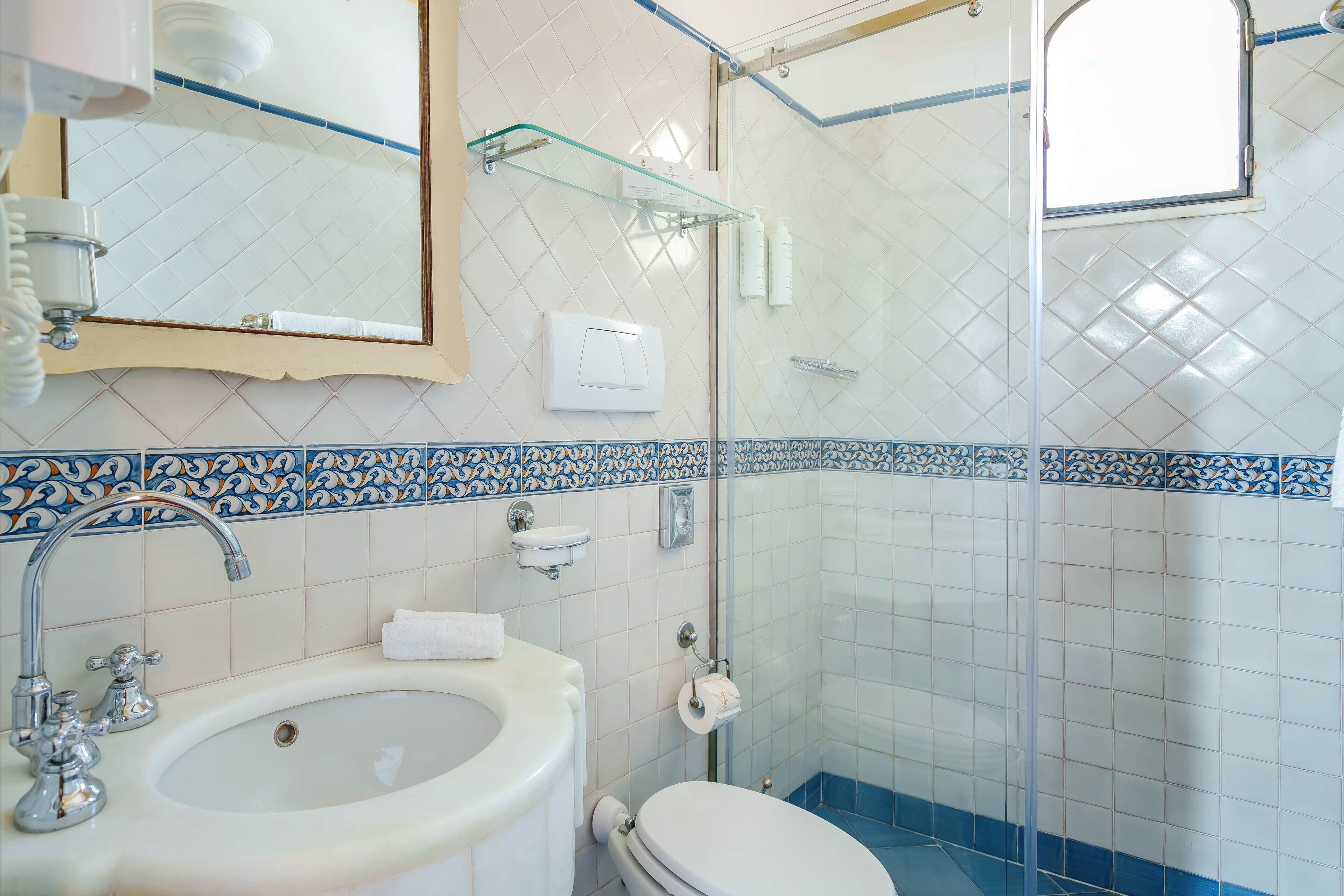 Une salle de bain comprenant un lavabo, des toilettes et un espace douche.