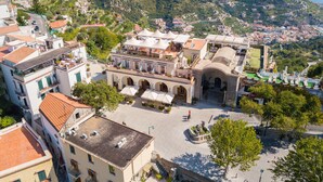 Un hôtel doté d’une cour intérieure, entouré de vignobles en terrasses et bordé par un paysage montagneux.