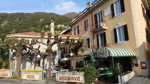 Een klassiek Europees gebouw met een bord waarop 'Ristorante' staat en terrasplekken.