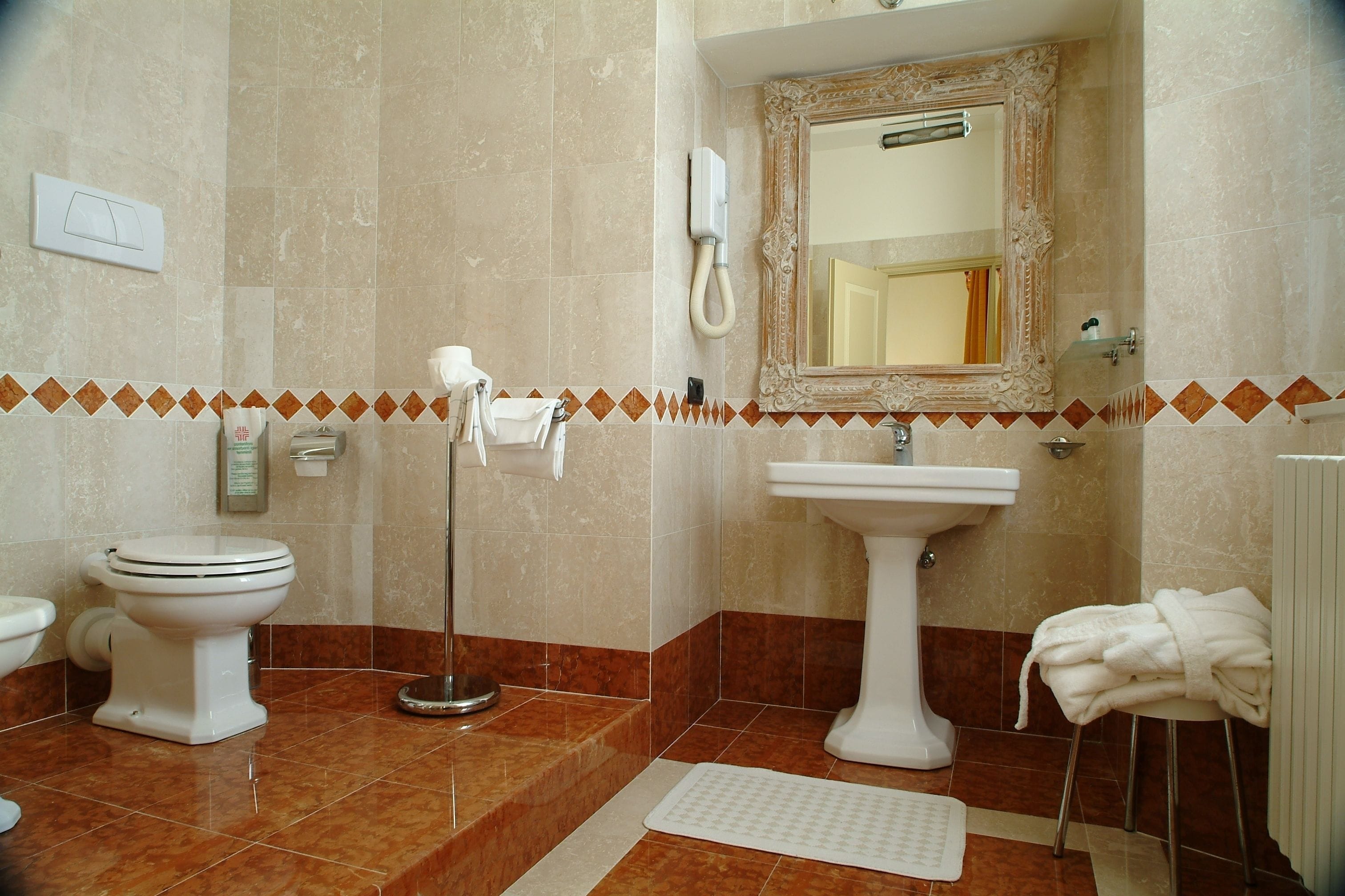 Un baño con inodoro, lavabo y espejo.