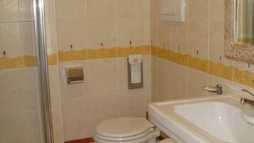 A bathroom with a toilet, a sink, and a shower.
