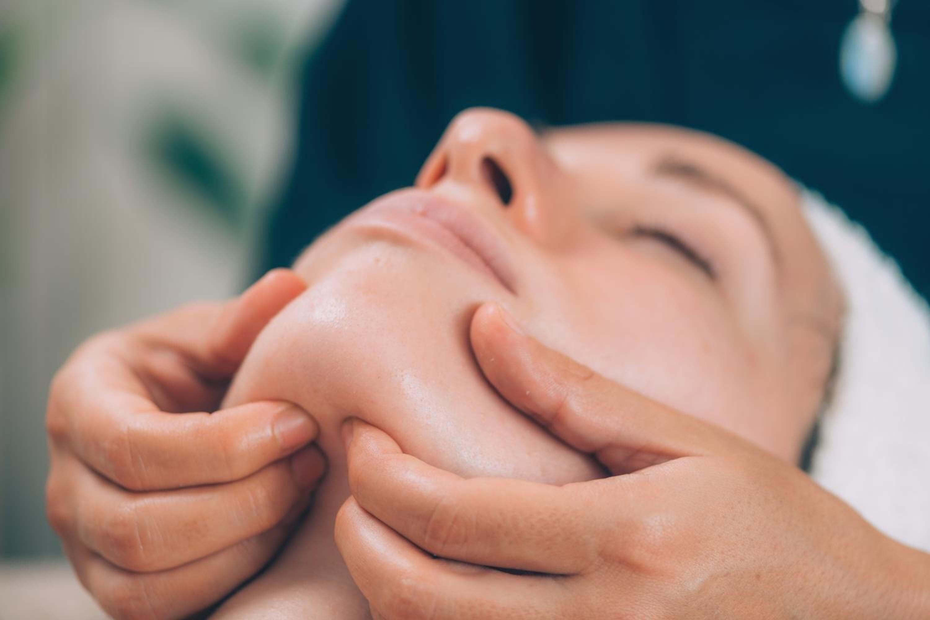 A close-up of hands gently holding a person's face.