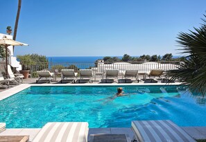 Piscine extérieure, parasols de plage, chaises longues