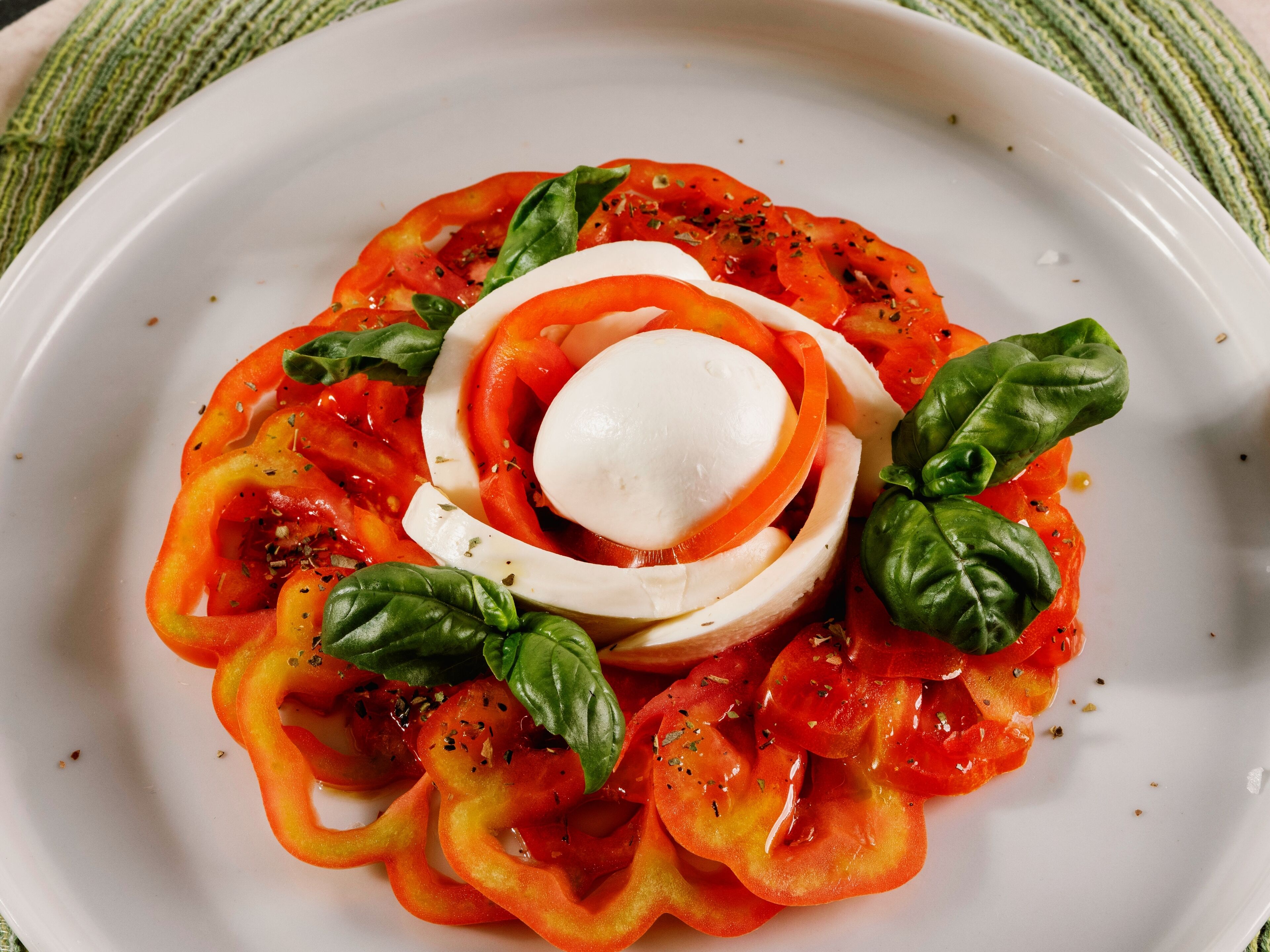 A plate of Caprese salad with tomatoes, mozzarella, and basil.