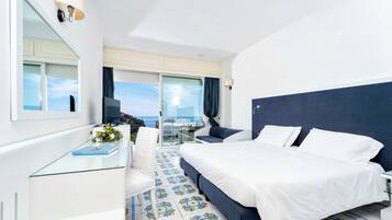 Hotelkamer met een bed, bureau, stoel, televisie en balkon met uitzicht.