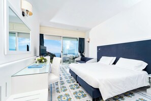 A hotel room with a bed, a desk, a chair, a TV, and a balcony with a view. - Hotel Regina Cristina  (Capri)