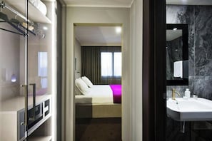 A hotel room with a bed, a bathroom with a sink, and a glass shower enclosure. - Hotel Don Pepe Terme & Beauty Farm (Lacco Ameno)