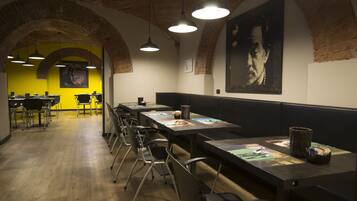 Een restaurant met hoge tafels, stoelen en hangende lampen.
