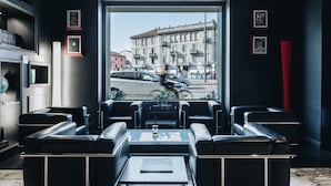 Un salón moderno con asientos de cuero y vistas a una calle de la ciudad.