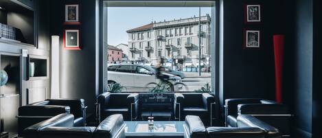 A modern lounge with leather seating and a view of a city street.