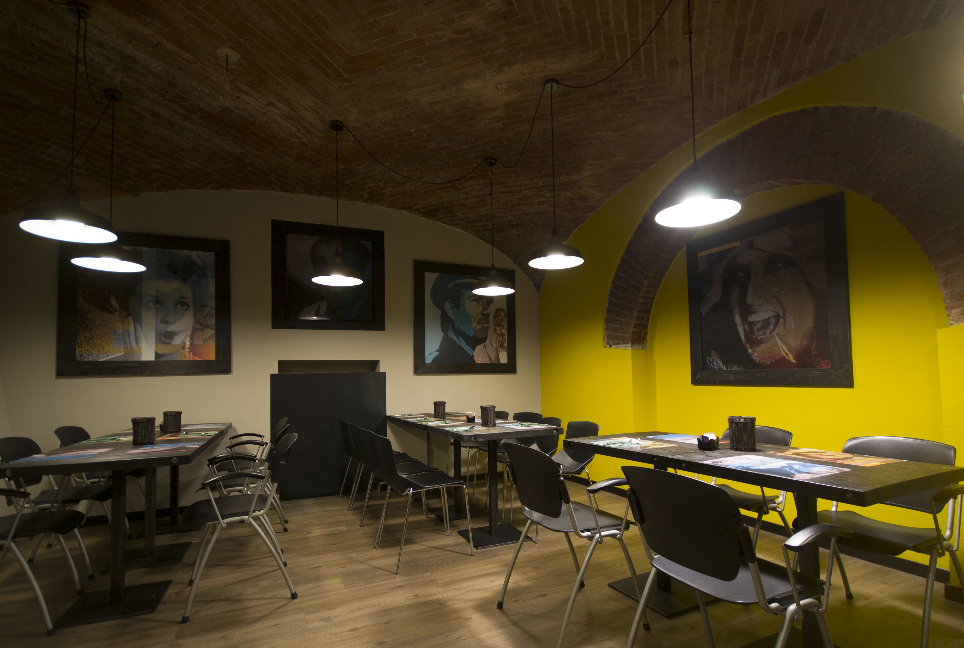 Un salón de conferencias con mesas, sillas y obras de arte en las paredes.