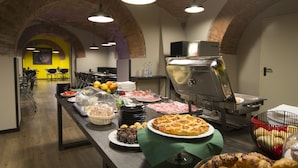 Montaje tipo bufé con diversas opciones de comida, una estación de parrilla y un área de comedor con mesas y sillas.