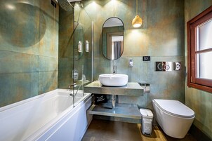 Een moderne badkamer met een bad, wastafel en toilet.