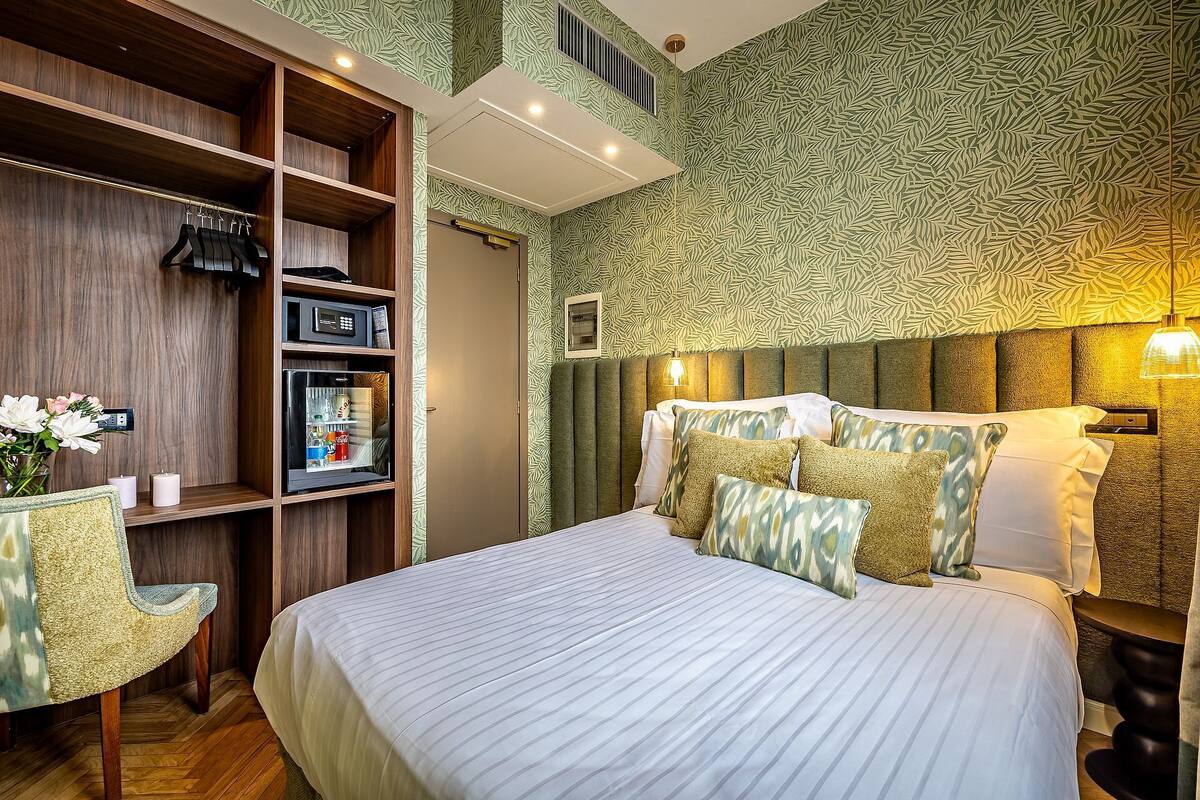 Una habitación de hotel con cama, armario, escritorio y silla.