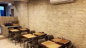Un restaurante con paredes de piedra, varias mesas y sillas.