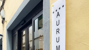 Señal con el nombre 'AURUMMUM HOTEL UFFIZI' colocada en un edificio.