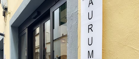 A sign for "AURUMMUM HOTEL UFFIZI" mounted on a building.