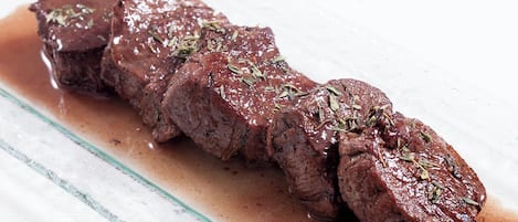 A steak with herbs on a plate.