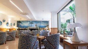Un comedor con sillas de diseño azulado, una mesa de madera y un mural que representa una playa.