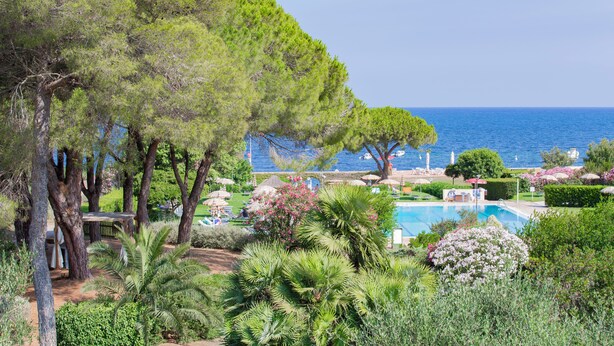 A pool area with a view of the sea, surrounded by trees and greenery. - Hotel Fabricia (Portoferraio)