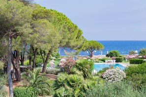 A pool area with a view of the sea, surrounded by trees and greenery. - Hotel Fabricia (Portoferraio)