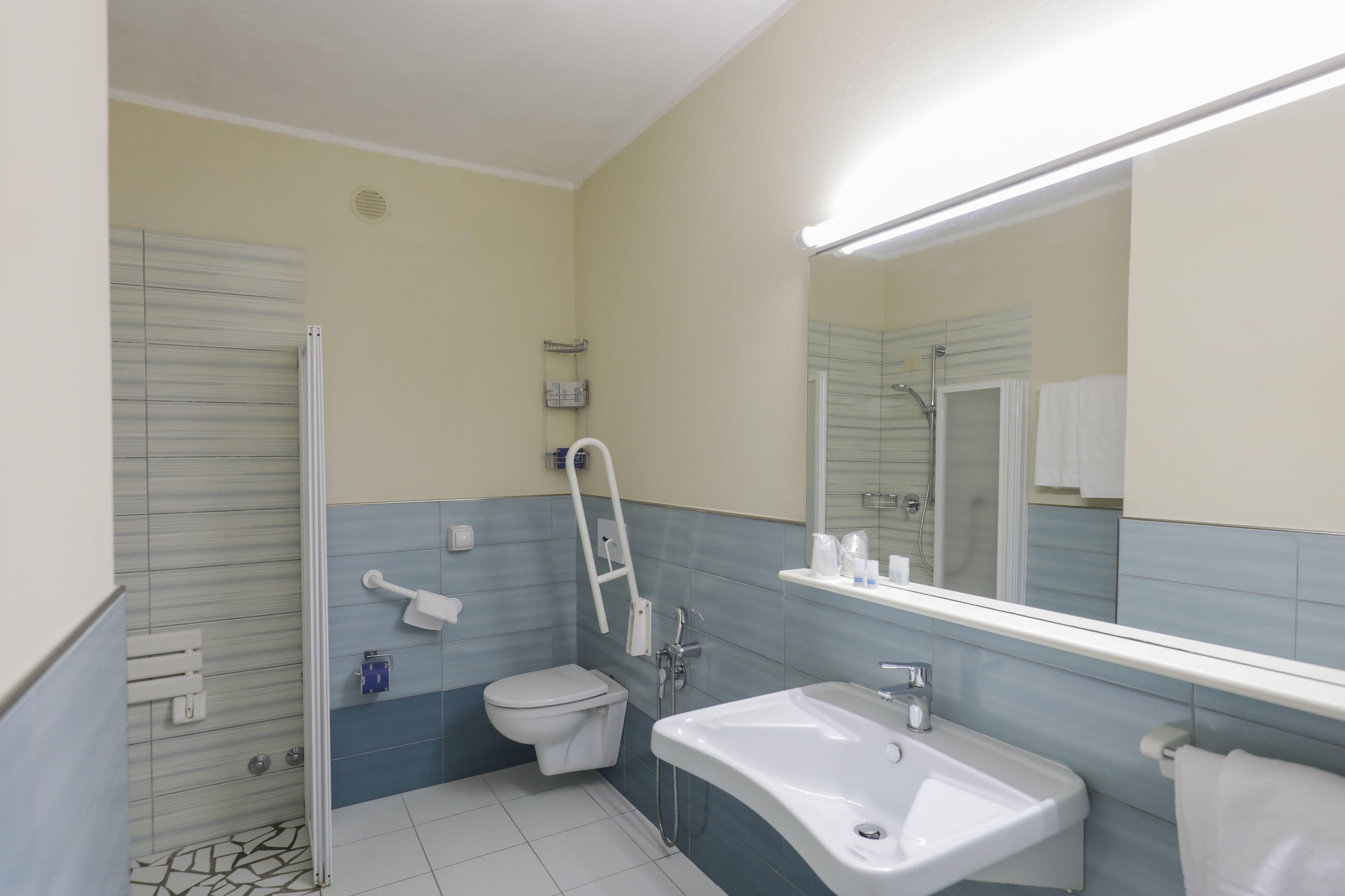 Une salle de bain moderne équipée de toilettes, d’un lavabo et d’une douche.