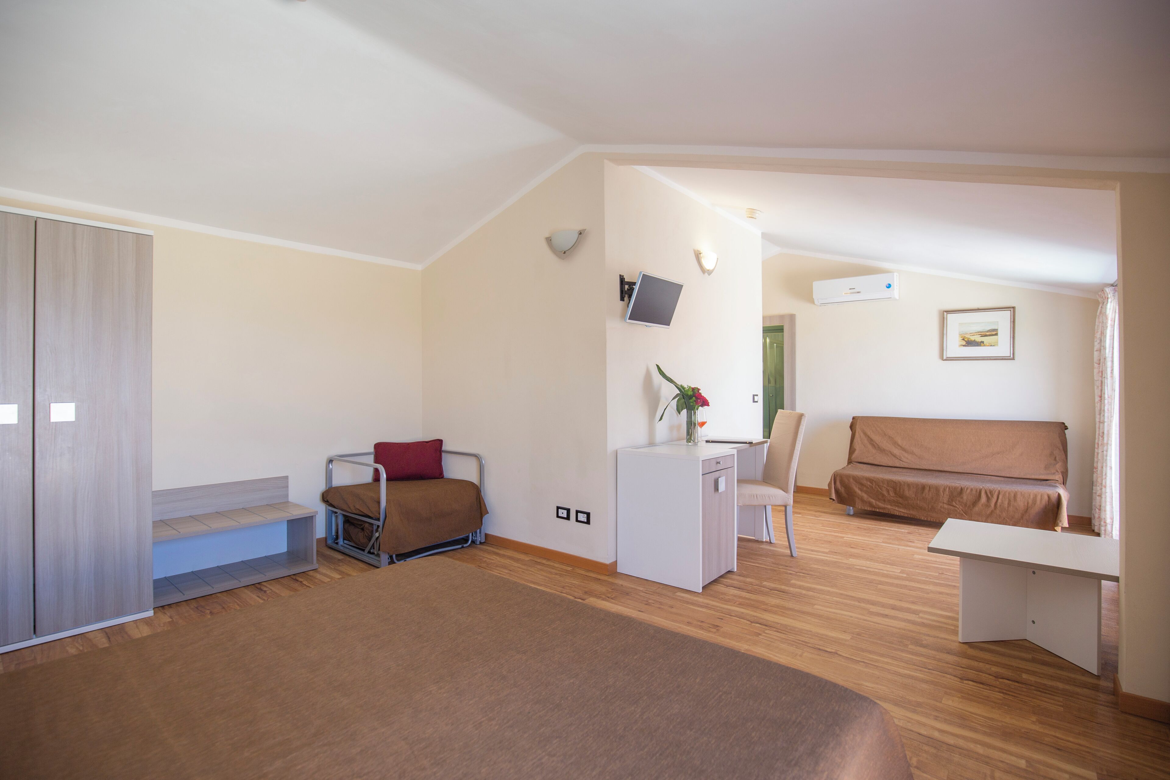 Une chambre moderne comprenant un lit, un bureau, une chaise, un canapé et une petite table.