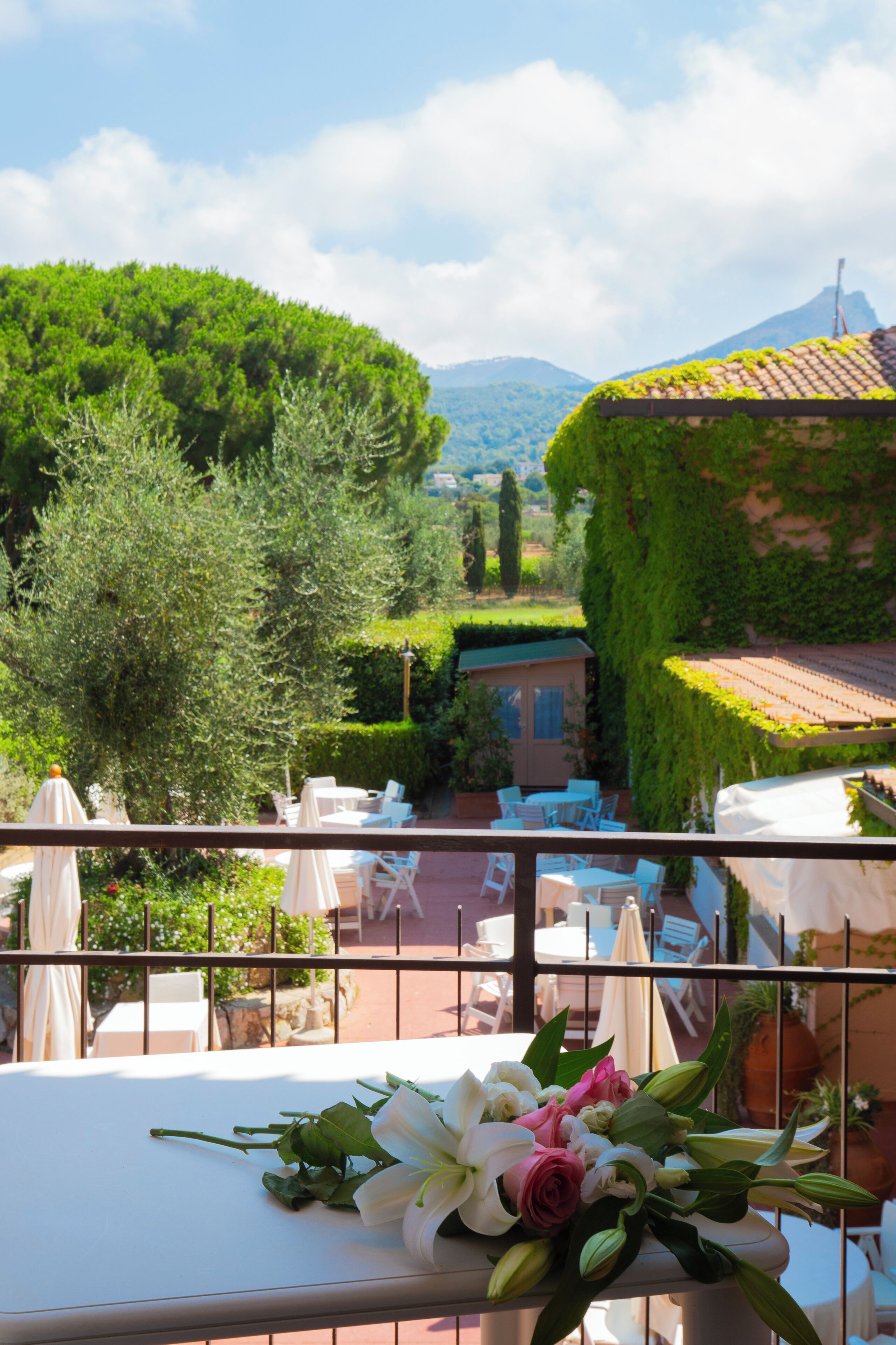 A terrace with outdoor seating and a table with a floral arrangement.