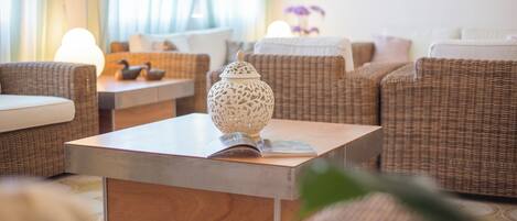 A cozy living room with wicker furniture, a wooden coffee table, and decorative items.