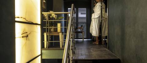 A modern interior with a staircase leading to a room with a large window.
