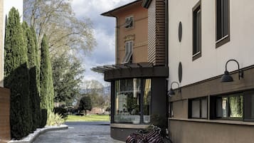 Ein Gebäude mit geschwungenem Eingang, einem Fahrradständer davor und einem Schild für einen Wellnessbereich.