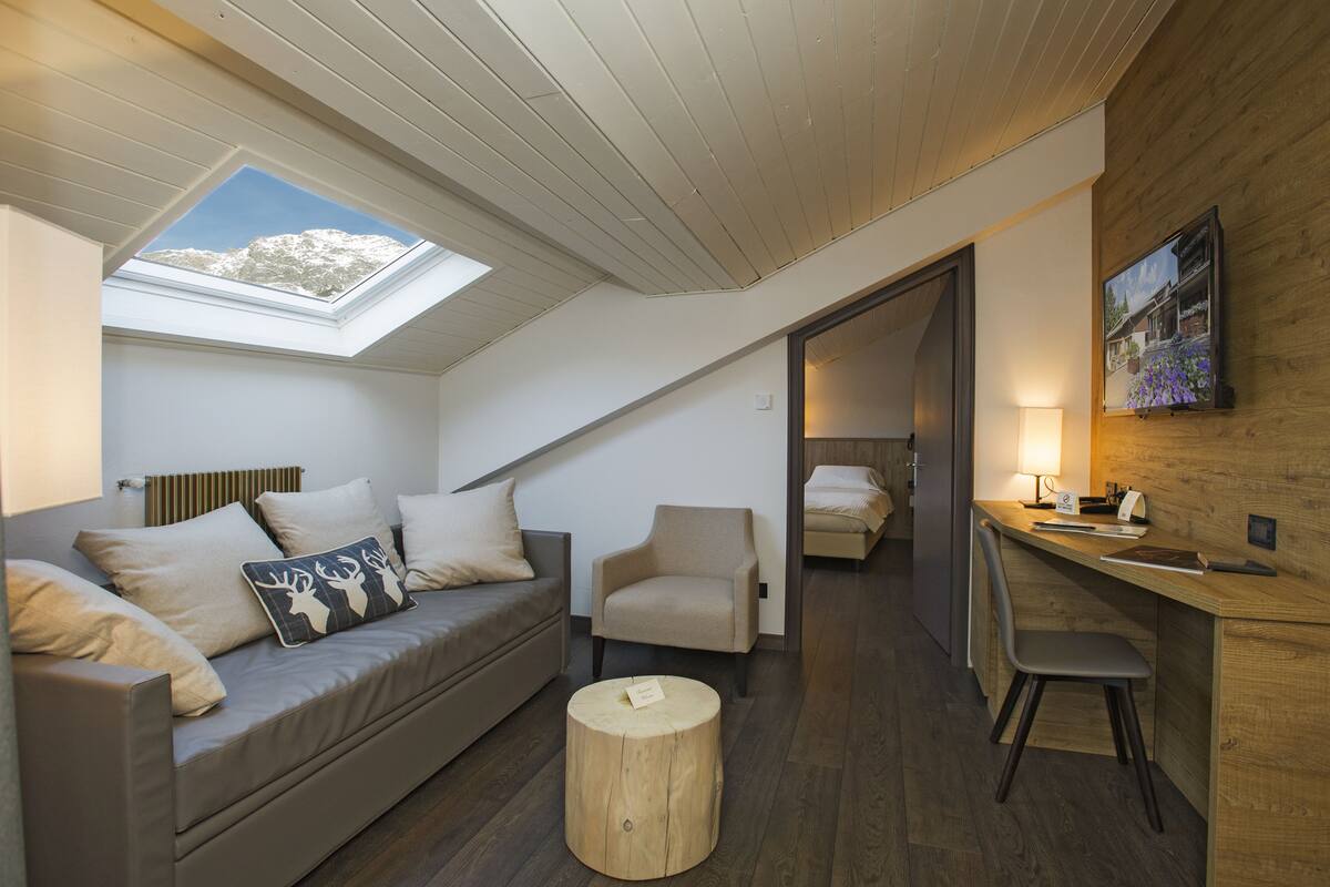 Ein modernes Schlafzimmer im Loftsstil mit Oberlicht, einer gemütlichen Sitzecke und einem Arbeitsplatz.