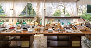 Una mesa de buffet con diversos alimentos y utensilios.