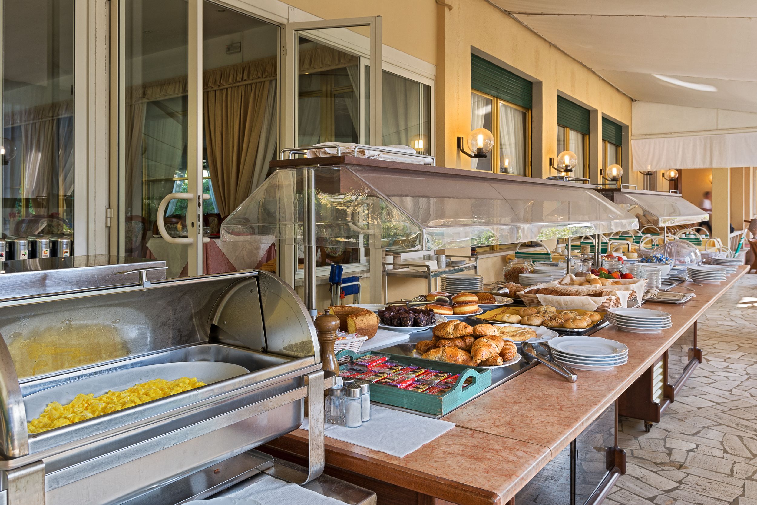 A buffet with various food items and a glass display case.