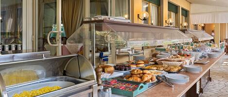 A buffet with various food items and a glass display case.