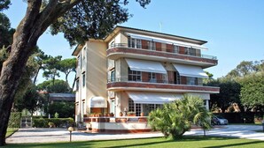 Un edificio moderno de dos pisos con un balcón curvo, un garaje y un césped bien cuidado.
