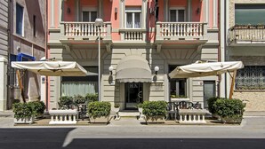 A multi-story building with balconies, a central entrance, and outdoor seating areas. - Hotel Katy (Viareggio)