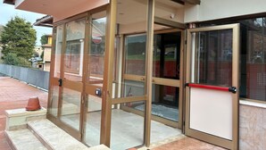 A building entrance with glass doors and a covered area. - Hotel La Magione (Poggibonsi)