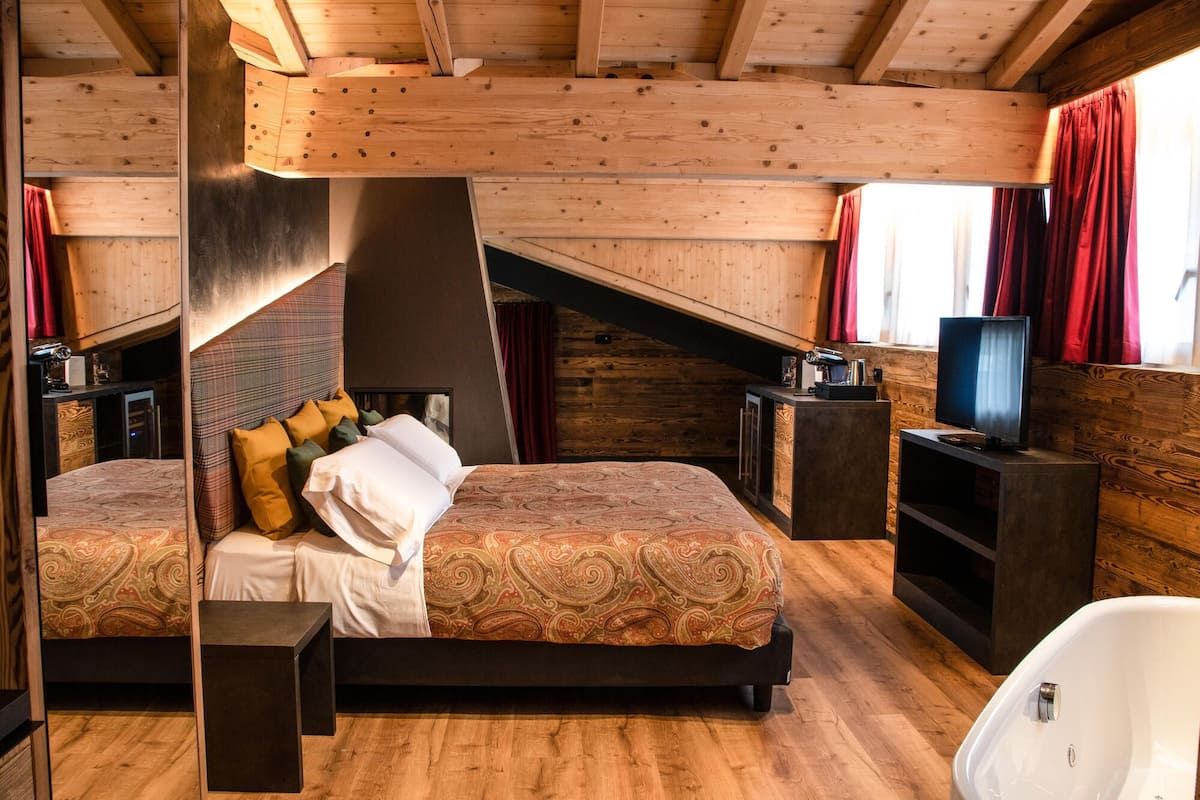 Un dormitorio con dos camas, televisión y chimenea.
