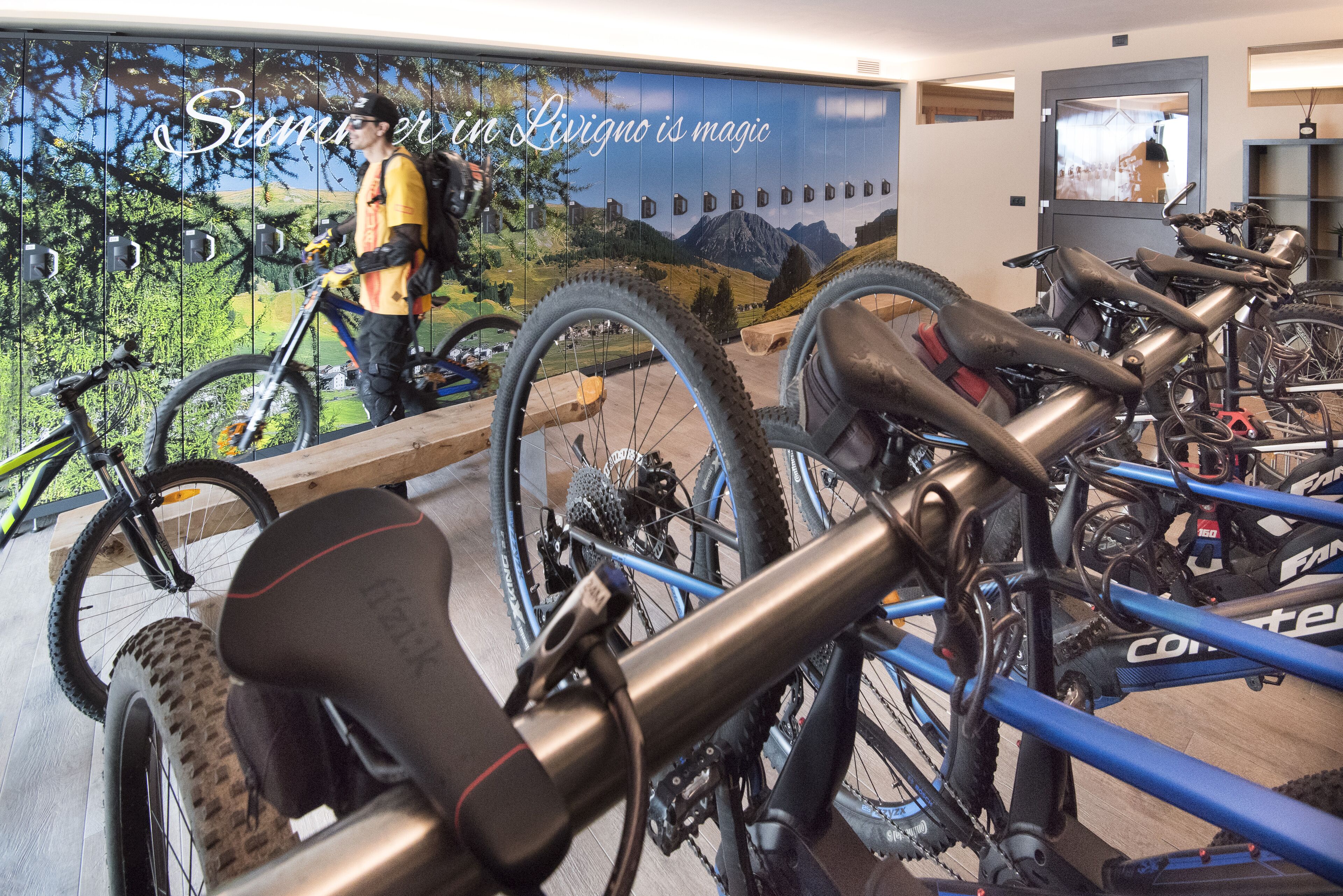 A bicycle rental station with multiple bikes and a person walking by.