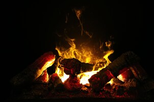 Un primo piano di un fuoco con fiamme vivaci e braci incandescenti.