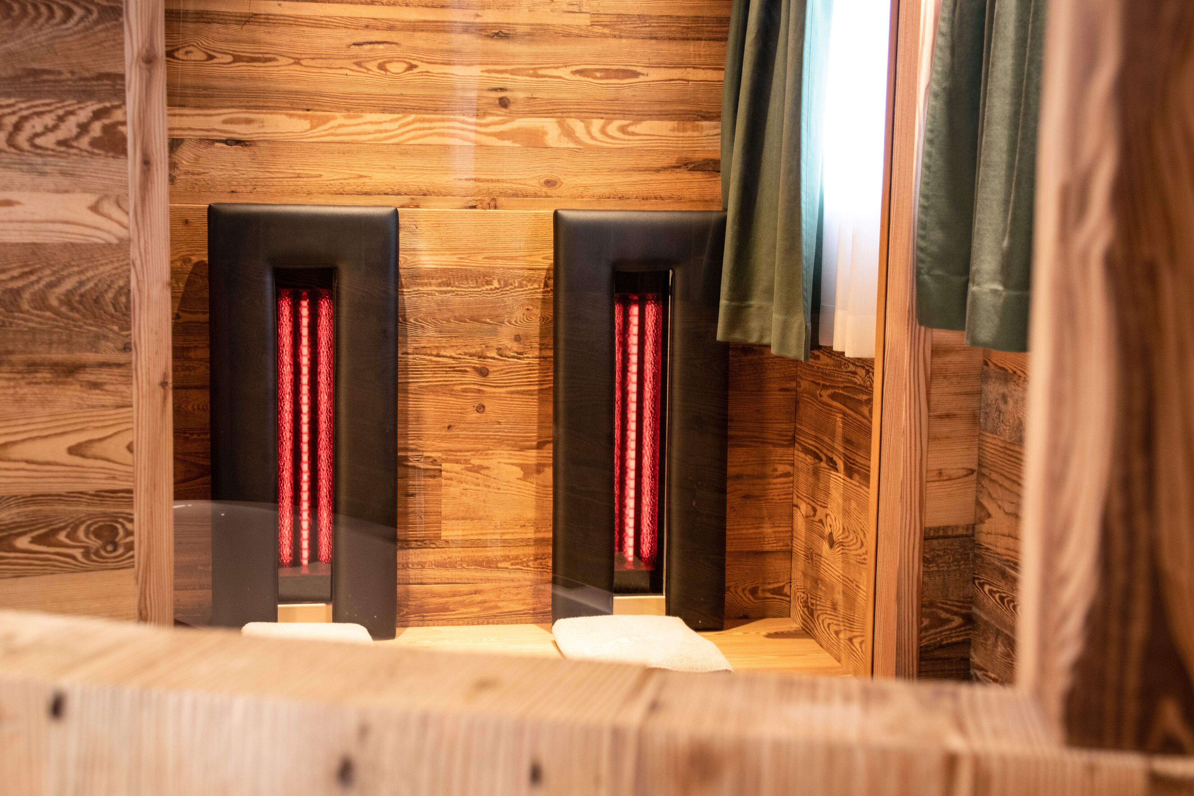 Un muro in legno con due pannelli neri contenenti luci rosse, probabilmente per il riscaldamento o l'illuminazione.