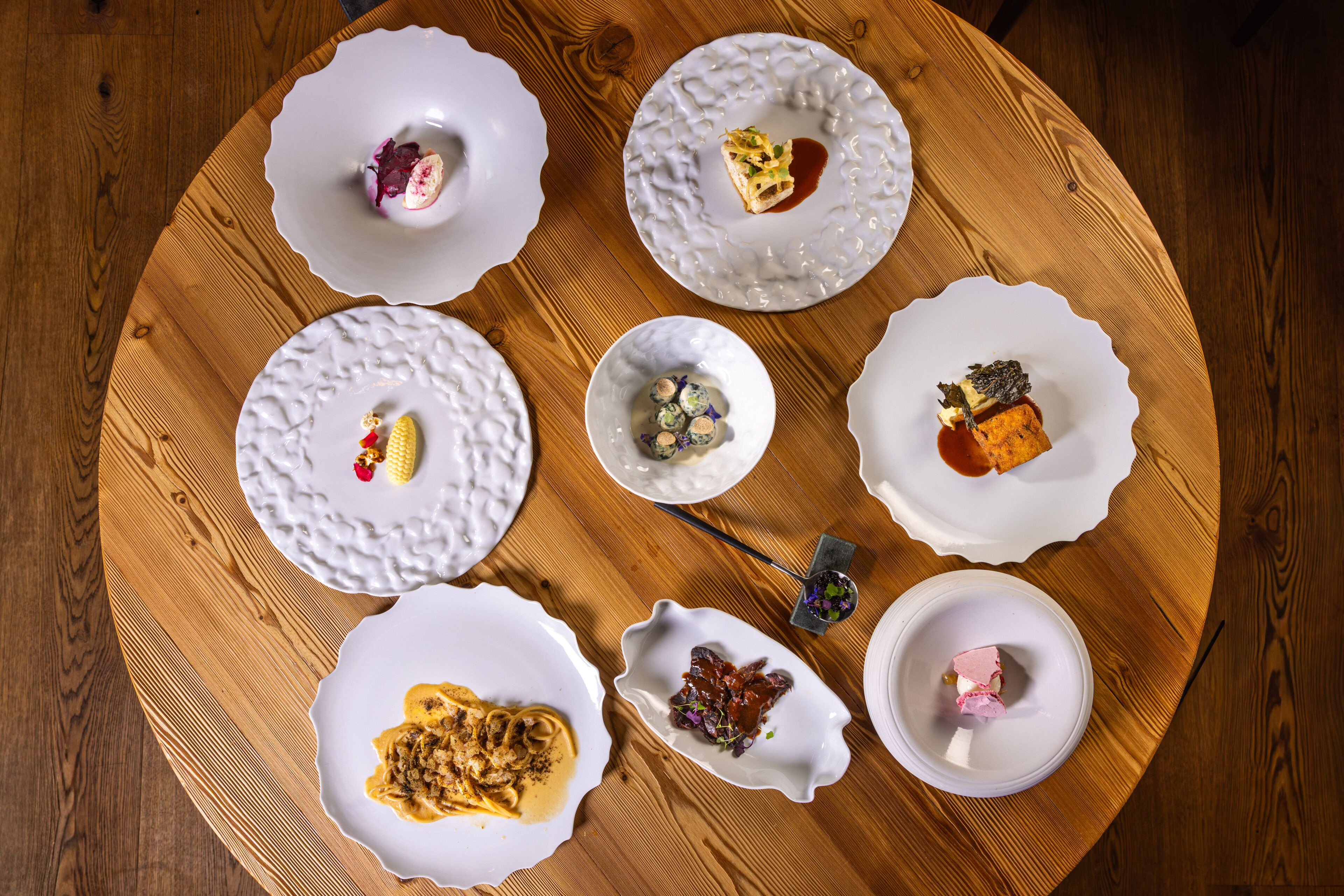 A round wooden table with various dishes of food.