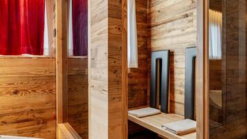 A wooden bathroom with a bathtub, a shower area, and a vanity with a mirror.