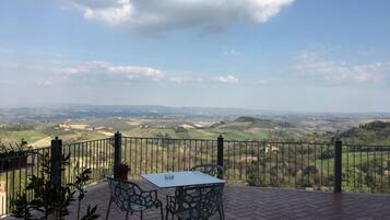Una terrazza con tavolo e sedie, affacciata su un panorama mozzafiato.