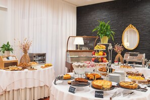 A buffet setup with various food items and a coffee station. - Hotel Castello (Castel San Pietro Terme)